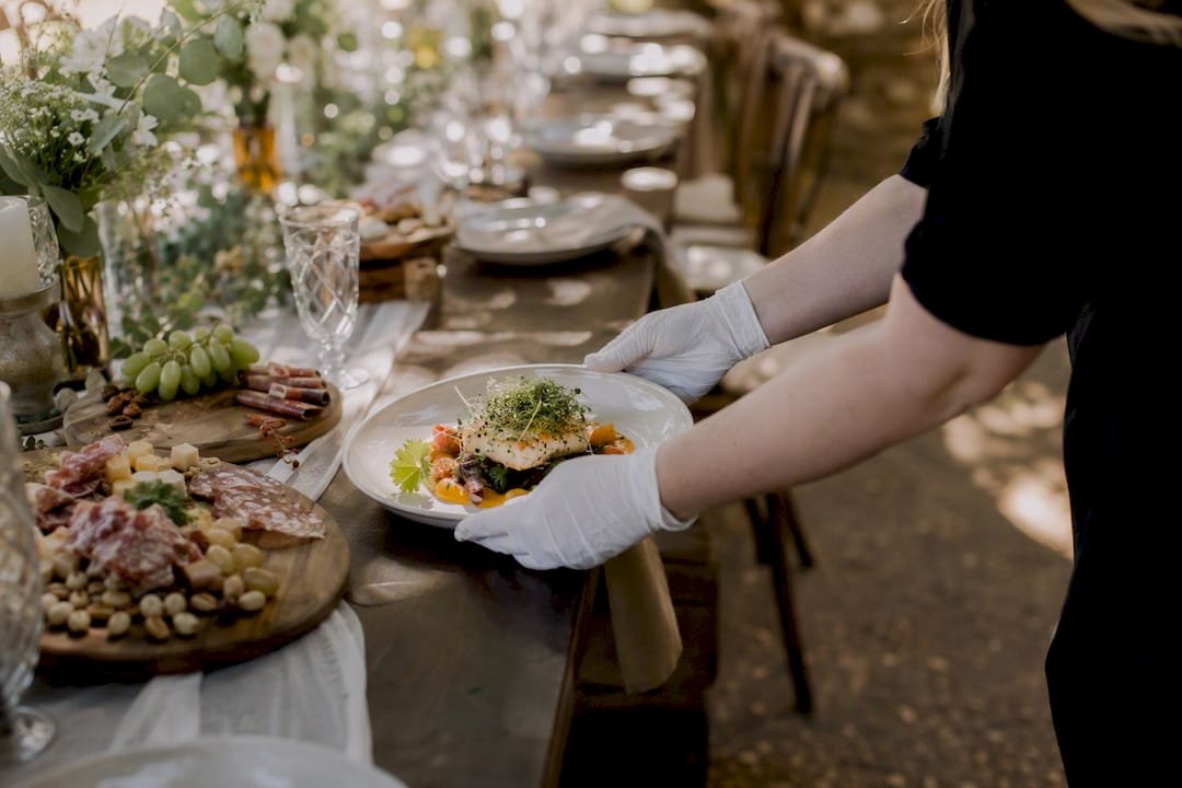 Catering hands placing allergy meal plate